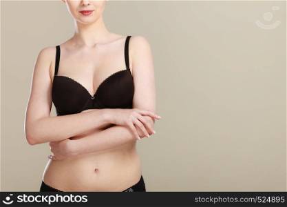 Woman wearing black bra lingerie taking care of her breasts, closeup female chest in underwear. Girl getting comfortable in brassiere. Girl getting comfortable in her bra