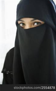 Woman wearing black veil indoors (high key)
