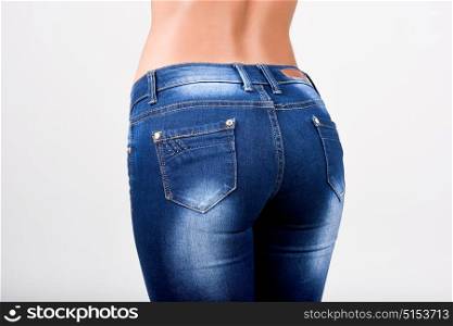 Woman wearing blue jeans with a beautiful waist. Studio shot
