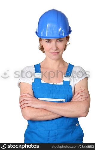 Woman wearing blue work overalls and hard hat