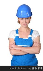 Woman wearing blue work overalls and hard hat