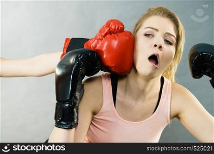 Woman wearing boxing gloves being punched in face during fight, she having jaw injury.. Woman getting punched in boxing fight