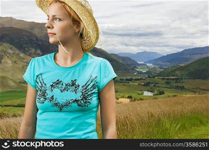 Woman wearing cowboy hat in countryside