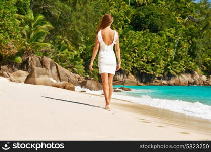 Woman wearing dress on beach Anse Intendance at Seychelles, Mahe