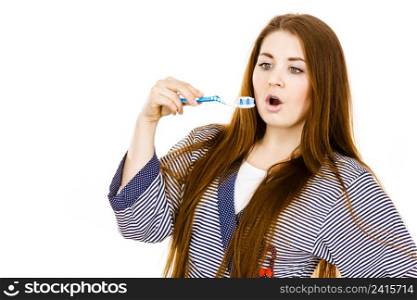 Woman wearing dressing gown holding toothbrush with paste on it. Smiling positive girl ready to cleaning teeth. Oral hygiene. Isolated on white. Woman holds toothbrush with paste.