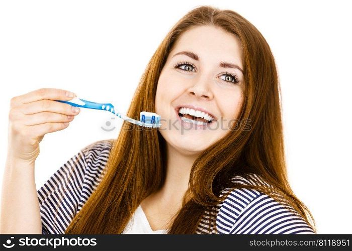 Woman wearing dressing gown holding toothbrush with paste on it. Smiling positive girl ready to cleaning teeth. Oral hygiene. Isolated on white. Woman holds toothbrush with paste.