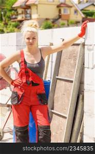 Woman wearing dungarees about to do some work on construction site. Women power, gender equality, industrial worker.. Woman in dungarees working on construction site