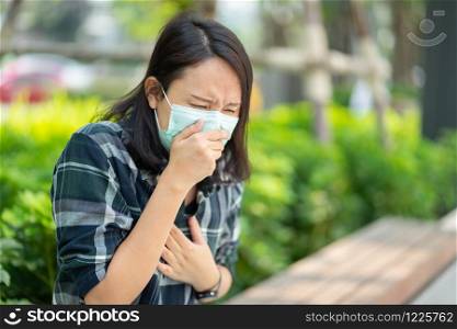 Woman wearing face mask protect filter against air pollution (PM2.5) or wear N95 mask. protect pollution, anti smog and viruses, Air pollution caused health problem. environmental pollution concept.