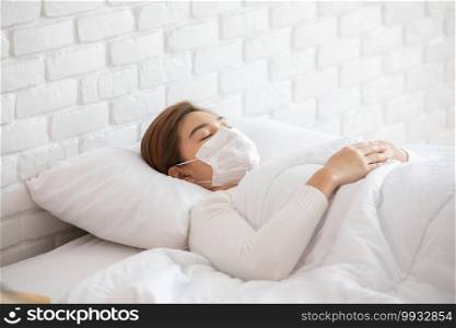 woman wearing face protection mask lying on bed has fever by corona virus 2019 or COVID-19 after travel from China,Coronavirus Concept