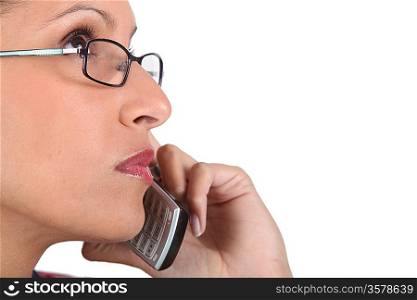 Woman wearing glasses using telephone