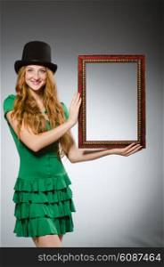 Woman wearing green dress holding picture frame