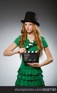 Woman wearing green dress with movie board