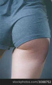 Woman wearing grey shorts showing her buttock. Feminine curves, slim sporty body shape.. Woman wearing grey shorts showing her buttock.