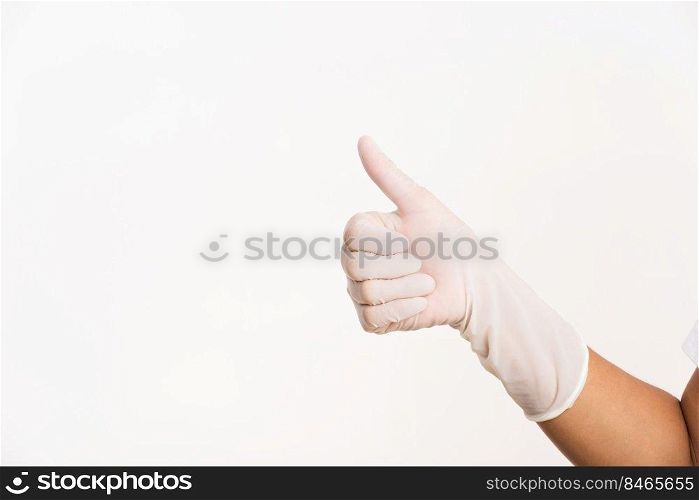 Woman wearing hand to white rubber latex surgical medical glove for doctor with thumb up finger gesturing, studio shot isolated on white background, Hospital medical infection control concept