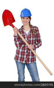 Woman wearing hard hat and holding shovel