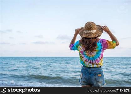 woman wearing hat standing on the sea beach