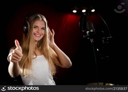 woman wearing headphones showing thumbs up
