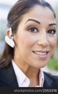 Woman wearing headset outdoors smiling (selective focus)