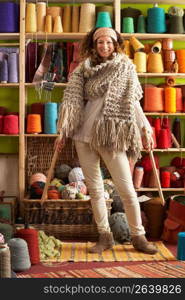 Woman Wearing Knitted Scarf Standing In Front Of Yarn Display