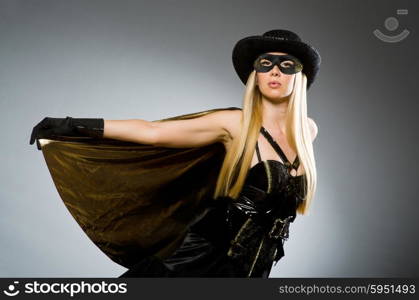 Woman wearing mask against dark background