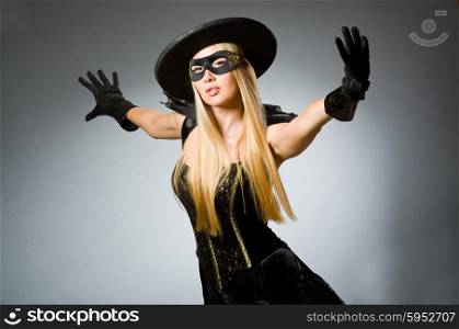 Woman wearing mask against dark background