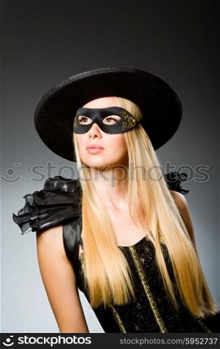 Woman wearing mask against dark background
