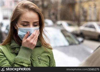 woman wearing mask holding her hand her face