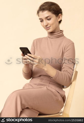 woman wearing monochrome clothes using mobile phone