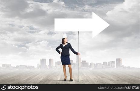 Woman wearing paper crown. Young businesswoman in paper crown carrying blank banner. Place for text