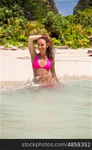 Woman wearing pink bikini on tropical beach at Thailand