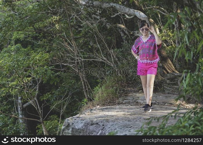 woman wearing pink color of clothes shirt standing in rock cliff of khao yai national park thailand