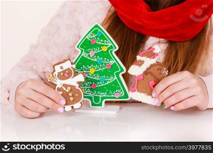 Woman wearing red xmas hat playing with gingerbread cookies little snowman and claus. Happy girl awaiting christmas holidays. Woman santa claus hat with gingerbread cookies. Christmas
