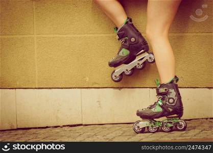 Woman wearing roller skates in town. Female being sporty during summer time.. Woman wearing roller skates