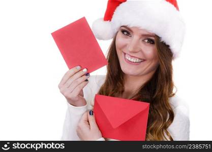 Woman wearing santa claus hat holding red envelope reading children letter or wish list. Positive face expression. Christmas time. Studio shot isolated on white. Woman in santa claus hat reading letter