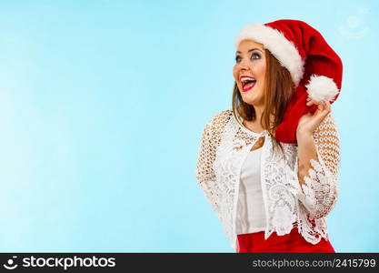 Woman wearing santa claus hat surprised shocked face expression, on blue. Christmes time.. Shocked santa claus christmas woman