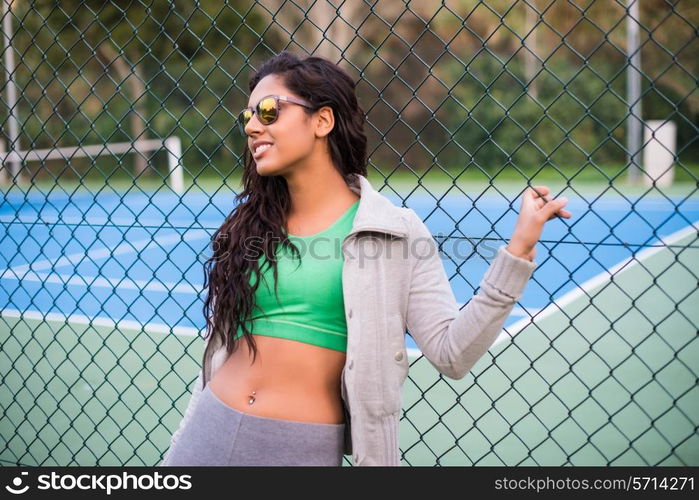 Woman wearing sunglasses over tennis court background