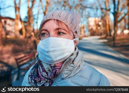 Woman wearing the face mask to avoid virus infection and to prevent the spread of disease. Virus infection protection. Real people, authentic situations