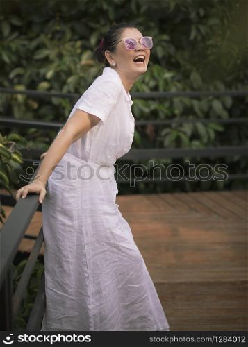 woman wearing white clothes toothy smiling face happiness emotion in green leaves garden