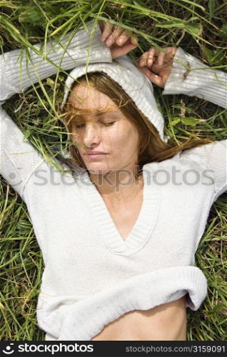 Woman wearing white lying in grass