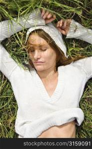 Woman wearing white lying in grass