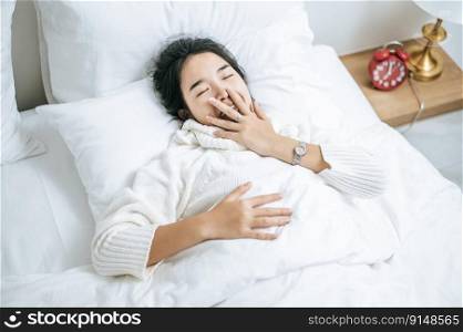 Woman wearing white shirt sleeping on the bed and white pillows.