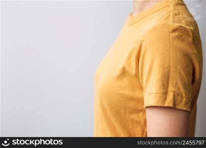 Woman wearing yellow color t shirt on gray background with copy space for text