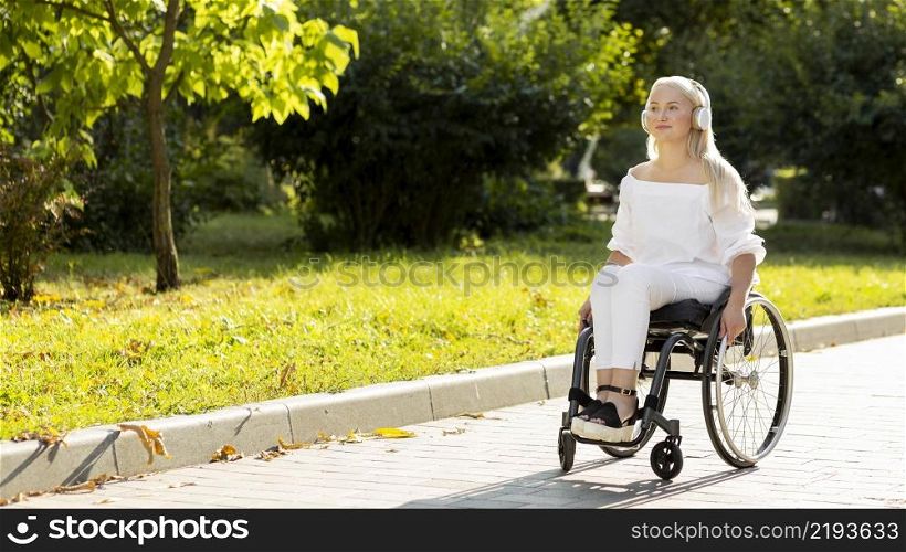 woman wheelchair listening music outdoors