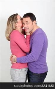 Woman whispering to her boyfriend&acute;s ear
