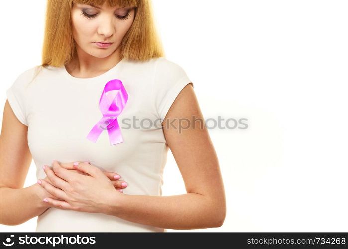 Woman wih pink cancer ribbon on chest. Sad, worried and concerned facial expression. Health care, medicine and breast cancer awareness concept. . Woman sad girl wih pink cancer ribbon on chest