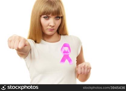 Woman wih pink ribbon on chest punching boxing. Fight against disease. Healthcare, medicine and breast cancer awareness concept