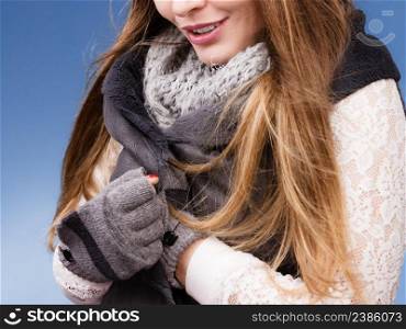 Woman winter fashion girl wearing warm clothing scarf gloves on blue studio shot. Winter fashion girl wearing warm clothes 