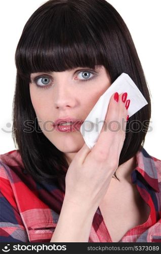 Woman wiping her face with a tissue