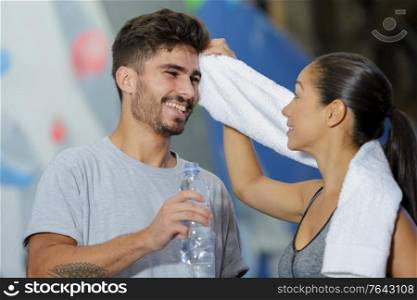 woman wiping the sweat of her wall climber boyfriend