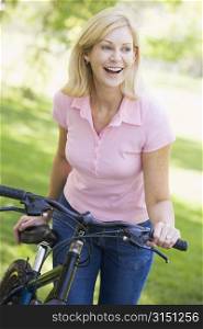 Woman with a bike outdoors smiling